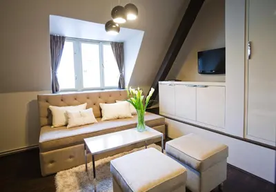 a living room with a couch and a tv at Design Hotel Jewel Prague in Prague