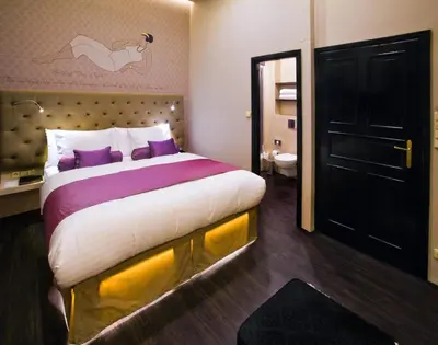 a bedroom with a large bed with purple pillows at Design Hotel Jewel Prague in Prague