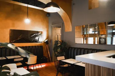 a dining room with tables and chairs and a bar at Design Hotel Jewel Prague in Prague