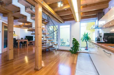 a living room with a staircase and a dining room at Attic Apartment by Wenceslas Square in Prague