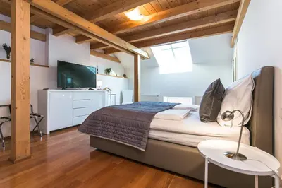 a bedroom with a bed and a tv and a table at Attic Apartment by Wenceslas Square in Prague
