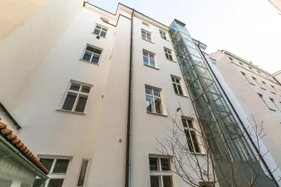 a white building with a glass facade at Attic Apartment by Wenceslas Square in Prague