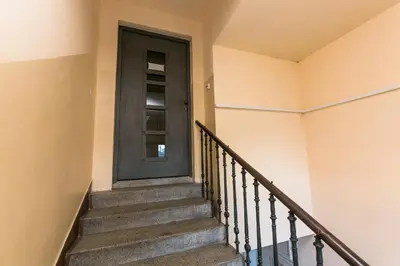 a staircase with a black door in a house at Attic Apartment by Wenceslas Square in Prague
