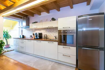 a kitchen with white cabinets and a stainless steel refrigerator at Attic Apartment by Wenceslas Square in Prague