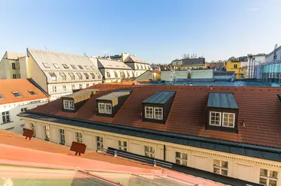 a view of roofs of buildings in a city at Attic Apartment by Wenceslas Square in Prague