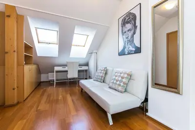 a living room with a white couch and a table at Attic Apartment by Wenceslas Square in Prague