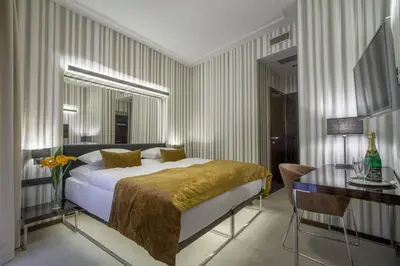 a bedroom with a bed and a table and a desk at Clementin in Prague