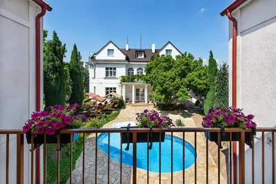 a large blue swimming pool in front of a house at Marie - Luisa in Prague