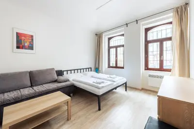 a living room with a blue couch and a table at Family Apartments Praha 6 in Prague