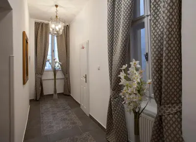 a hallway with a vase of flowers and a window at Residence Corto Old Town in Prague
