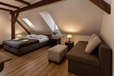 a bedroom with two beds and a chair and a couch at Residence Corto Old Town in Prague
