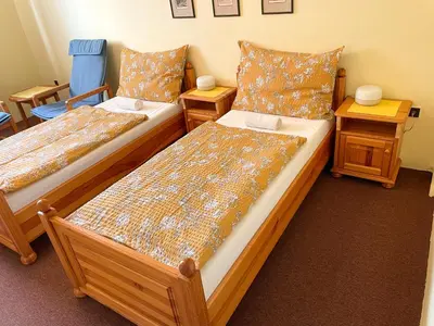 two beds in a room with two night stands and two tables at Ubytování Kubantovi in Prague
