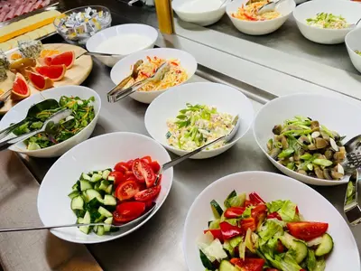 a table topped with white bowls of different types of food at Hotel Askania in Prague