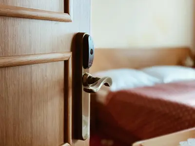 a doorhandle to a bedroom with a bed at Hotel Askania in Prague