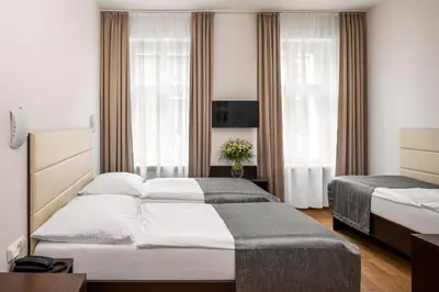 two beds in a hotel room with windows at Hotel Unique in Prague