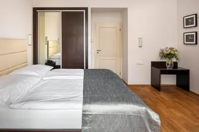 a bedroom with a large white bed and a table at Hotel Unique in Prague