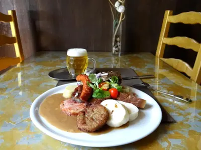 a plate of food with meat and vegetables on a table at Hotel U Kříže in Prague