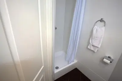 a bathroom with a shower and a white towel at Hotel U Kříže in Prague