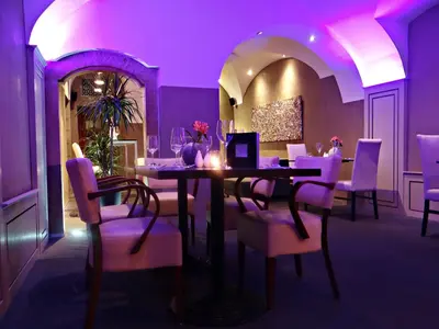 a purple dining room with a table and chairs at Hotel U Kříže in Prague