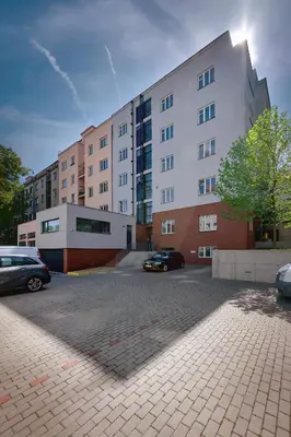 a large building with cars parked in a parking lot at DownTown Suites Belohorska in Prague