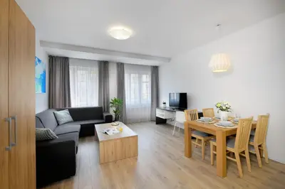 a living room with a couch and a table at DownTown Suites Belohorska in Prague