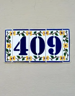 a blue and white sign on a wall with flowers at Villa Letná in Brandýs nad Labem-Stará Boleslav