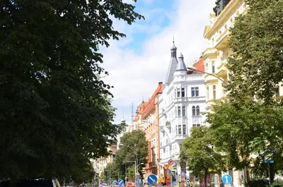a street in a city with buildings and trees at Homelike Prague Apartment in Prague