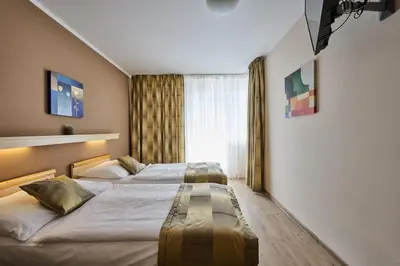 two beds in a hotel room with a window at Hotel Akademie in Chocerady