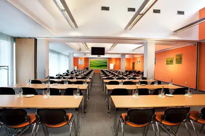 an empty lecture hall with tables and chairs at Hotel Akademie in Chocerady