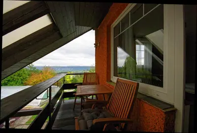 a balcony with two chairs and a table and a window at Cozy Gardens Apartments in Prague in Prague