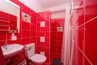 a red bathroom with a toilet and a sink at Cozy Gardens Apartments in Prague in Prague