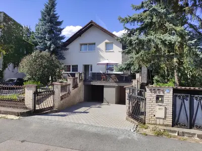 a white house with a gate and a driveway at Cozy Gardens Apartments in Prague in Prague
