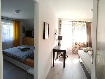 a bedroom with a bed and a desk and a window at Cozy Gardens Apartments in Prague in Prague