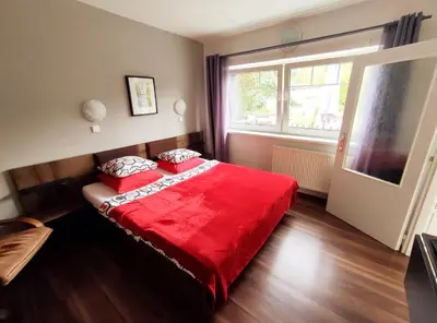 a bedroom with a red bed and a window at Cozy Gardens Apartments in Prague in Prague
