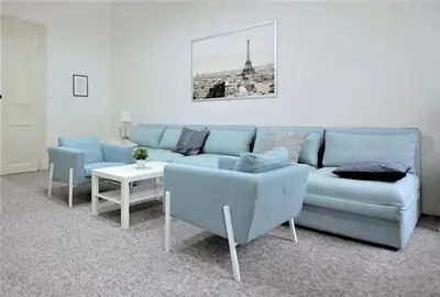 a living room with a blue couch and a table at Aparthotel Wenceslas in Prague