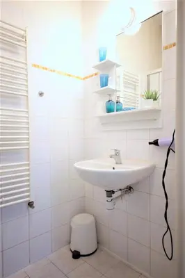 a white bathroom with a sink and a mirror at Aparthotel Wenceslas in Prague