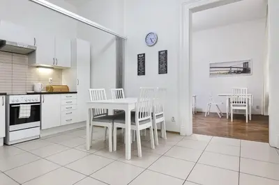a white kitchen with a white table and chairs at Aparthotel Wenceslas in Prague