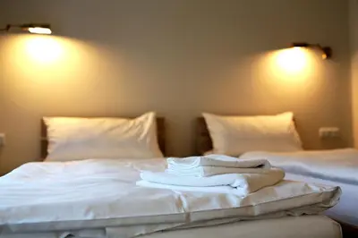 two beds with white sheets and towels on them at Statek 1738 in Všestudy