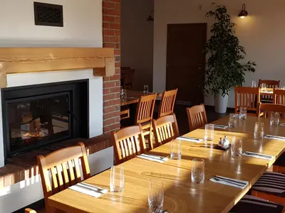 a dining room with a table and a fireplace at Statek 1738 in Všestudy