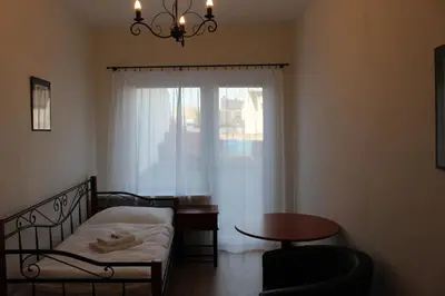 a room with a bed and a table and a window at Hotel Černý kůň in Louny