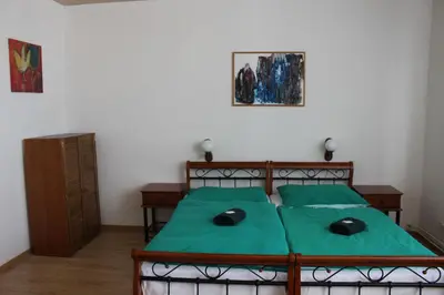 a bedroom with a bed with a green comforter at Hotel Černý kůň in Louny