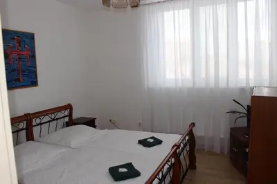 a bedroom with a bed with two black slippers on it at Hotel Černý kůň in Louny