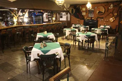 a restaurant with tables and chairs and a bar at Hotel Černý kůň in Louny