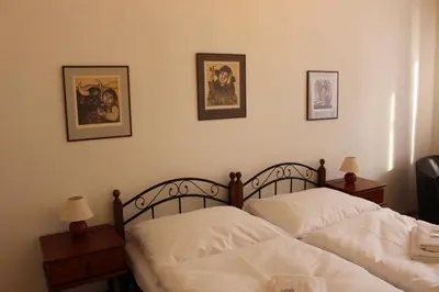 two beds in a bedroom with pictures on the wall at Hotel Černý kůň in Louny