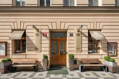 a building with two benches in front of it at Hunger Wall Residence in Prague