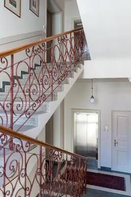 a staircase in a home with red metal railing at Hunger Wall Residence in Prague