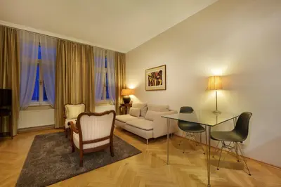 a living room with a couch and a table and chairs at Hunger Wall Residence in Prague