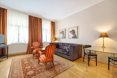 a living room with a couch and a table and chairs at Hunger Wall Residence in Prague
