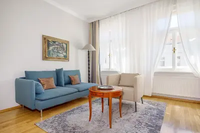 a living room with a blue couch and a table at Hunger Wall Residence in Prague