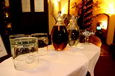 a table with a bottle of wine and glasses on it at The King Charles in Prague